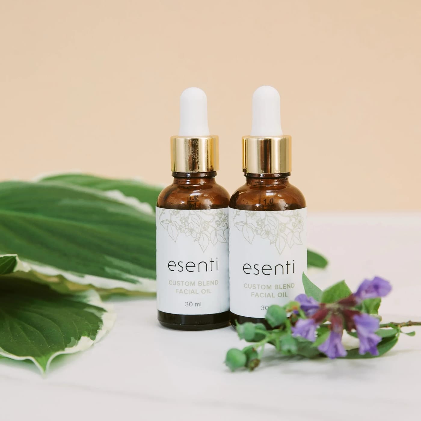 Two bottles of Esenti Custom Blend Facial Oil